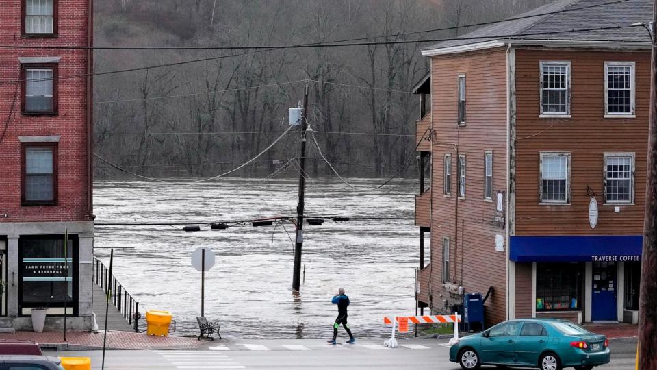 PHOTO: A man photographs the flooded Kennebec River, Dec. 19, 2023, in Hallowell, Maine.  (Robert F. Bukaty/AP)