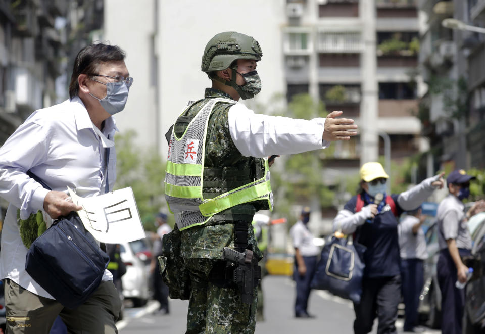 A Taiwan's soldier guides people to a basement shelter during the Wanan air raid drill in Taipei, Taiwan, Monday, July 25, 2022. Taiwan’s capital staged air raid drills Monday and its military mobilized for routine defense exercises, coinciding with concerns over a forceful Chinese response to a possible visit to the island by U.S. Speaker of the House Nancy Pelosi.(AP Photo/Chiang Ying-ying)