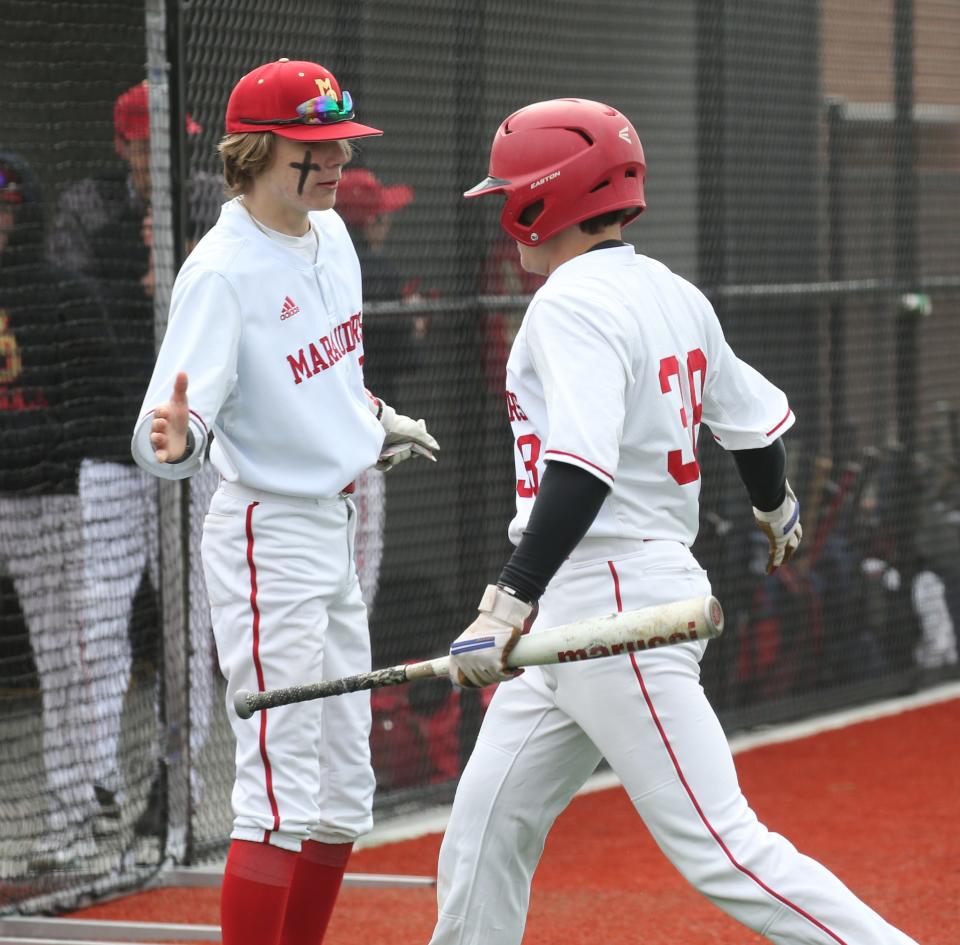 Jaden Rush greets Ben Nugent of Mt. Olive after Nugent crossed home plate scoring the first run as Mt. Olive High School unveiled and played their first game at their new baseball complex against West Morris on April 27, 2022.