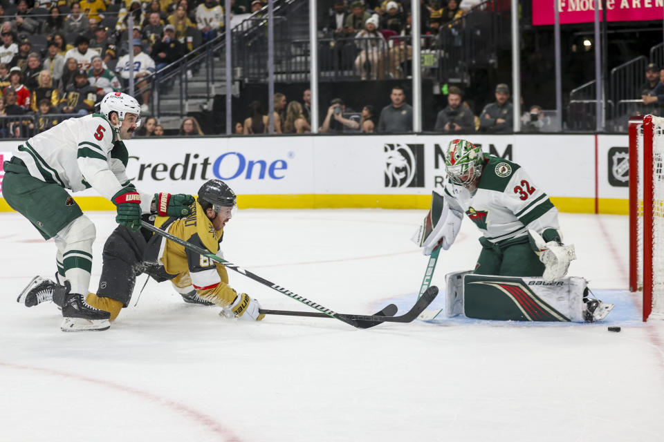 Minnesota Wild defenseman Jake Middleton (5) defends as Vegas Golden Knights right wing Jonathan Marchessault (81) falls while attempting a shot on Minnesota Wild goaltender Filip Gustavsson (32) during the second period of an NHL hockey game Monday, Feb. 12, 2024, in Las Vegas. (AP Photo/Ian Maule)