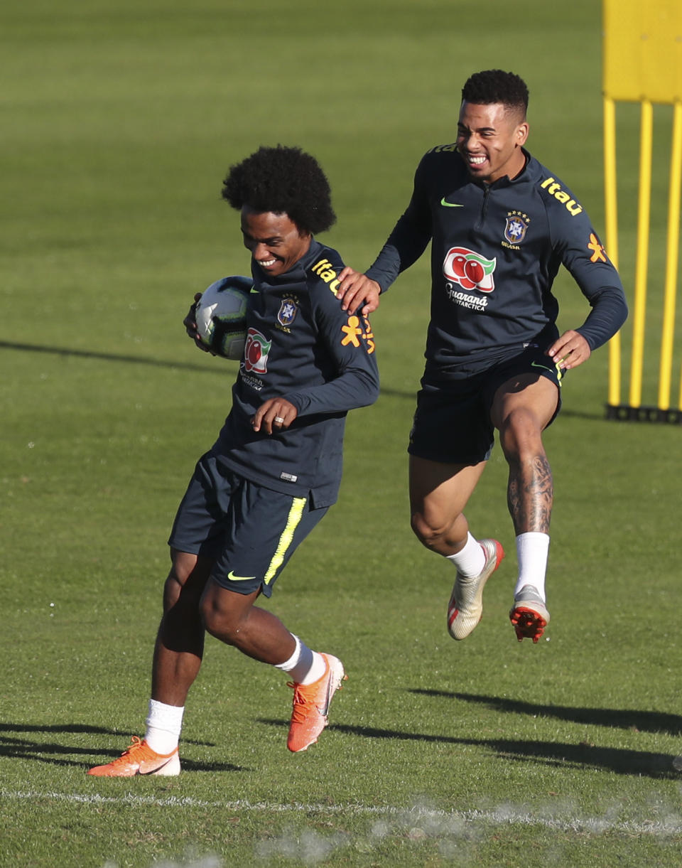 Willian holds a ball as Gabriel Jesus jumps during a training session of Brazil national soccer team in Porto Alegre, Brazil, Wednesday, June 26, 2019. Brazil will play against Paraguay for a Copa America quarter-final match on June 27.(AP Photo/Natacha Pisarenko)