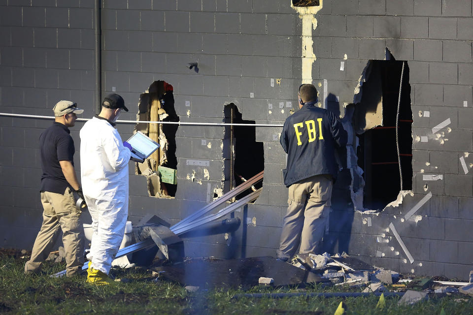 FBI agents investigate near the damaged rear wall of the Pulse Nightclub where Omar Mateen allegedly killed at least 50 people on June 12, 2016 in Orlando. | Joe Raedle—Getty Images