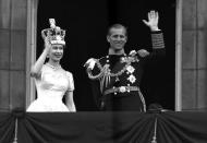 ARCHIVO - En esta foto del 2 de junio de 1953, la reina Isabel II de Gran Bretaña y el príncipe Felipe, duque de Edimburgo, saludan desde el balcón del Palacio de Buckingham, luego de la coronación de ella en la Abadía de Westminster, Londres. (AP Foto/Leslie Priest, File)