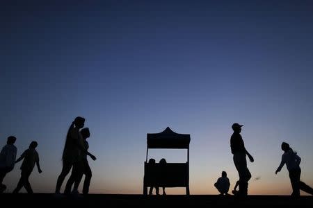 People walk and exercise by a lake in Yangon at sunrise December 3, 2011. REUTERS/Damir Sagolj