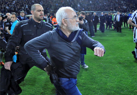 Russian-born Greek businessman and owner of PAOK Salonika, Ivan Savvides (C), pictured with what appears to be a gun in a holster, enters the pitch after the referee annulled a goal of PAOK during their soccer match against AEK Athens in Toumba Stadium in Thessaloniki, Greece, March 11, 2018. Intimenews via REUTERS