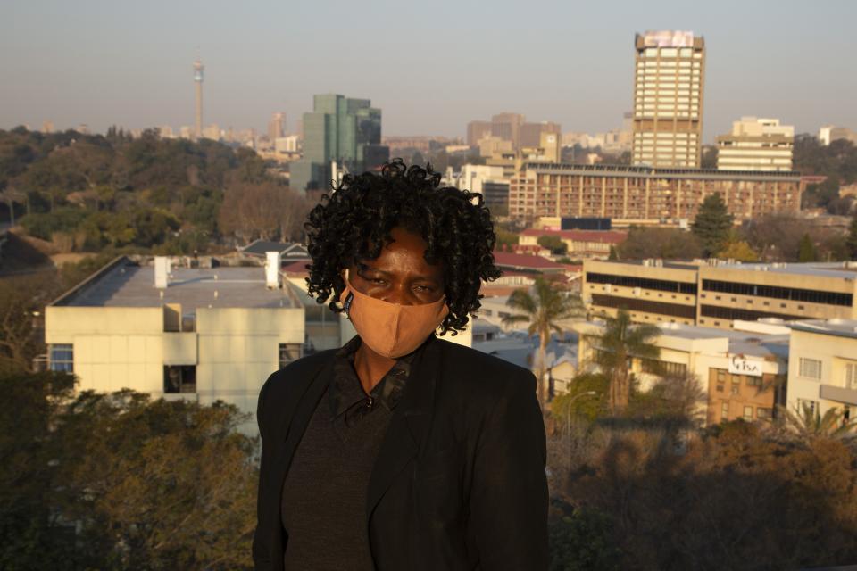 Security guard Ntando Sibanda poses for a photo at her place of employment in Johannesburg Thursday, July 23, 2020. Sibanda says "Masks must be worn to protect yourself and others and not spread the disease to one another and for my own safety" (AP Photo/Denis Farrell)