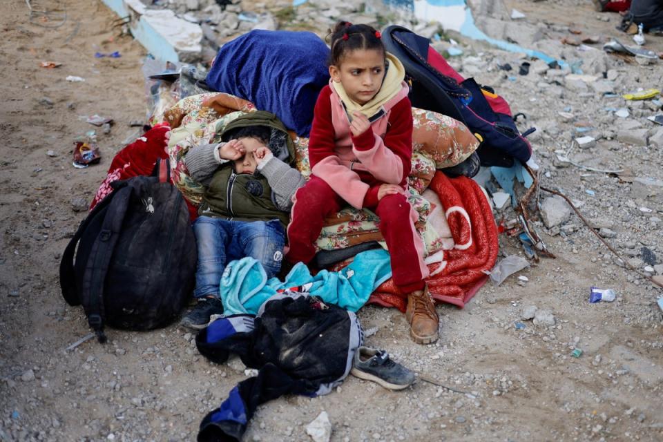 Children rest outside as Palestinian arrive in Rafah after they were evacuated from Nasser Hospital in Khan Younis (Reuters)