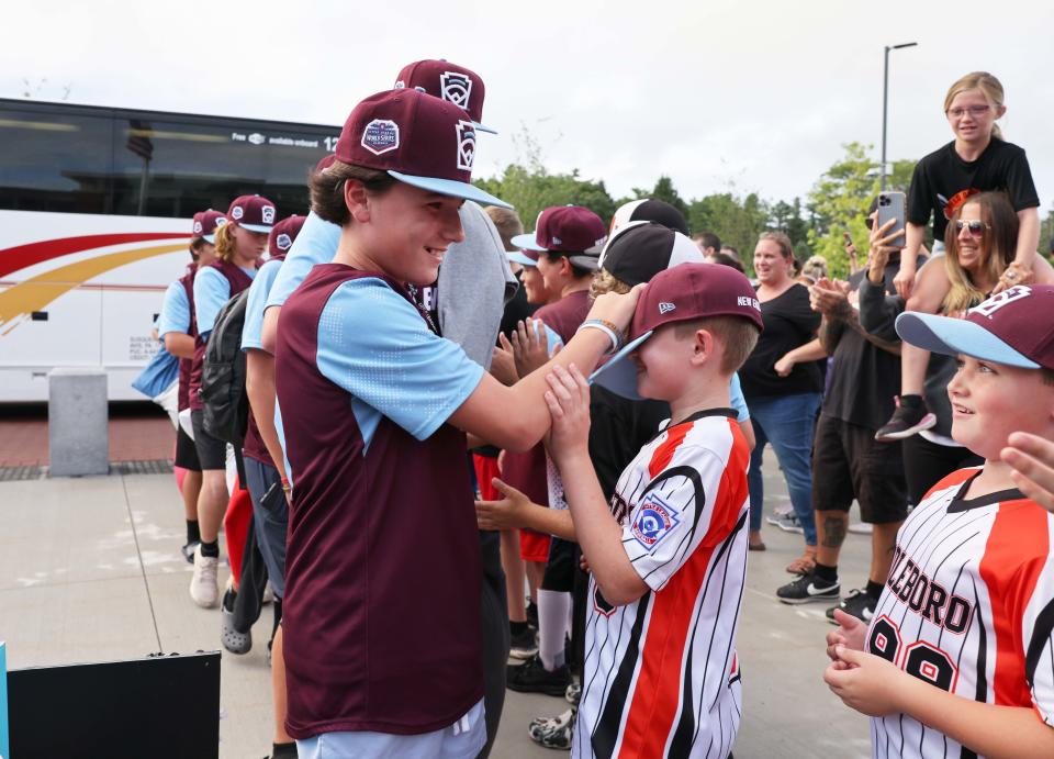 Middleboro 12U Nationals (New England) player Mike Marzelli high-fives a fan during a welcome home celebration from Williamsport, Pennsylvania, at Middleboro High School on Monday, Aug. 22, 2022.