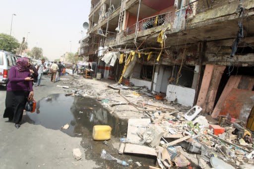 An Iraqi woman walks past destroyed shops on the ground floor of a building the day after twin car bombs in the Karrada area of Baghdad. July was the deadliest month in Iraq in almost two years, with 325 people killed in attacks, official figures released on Wednesday showed, and included the deadliest day here since December 2009