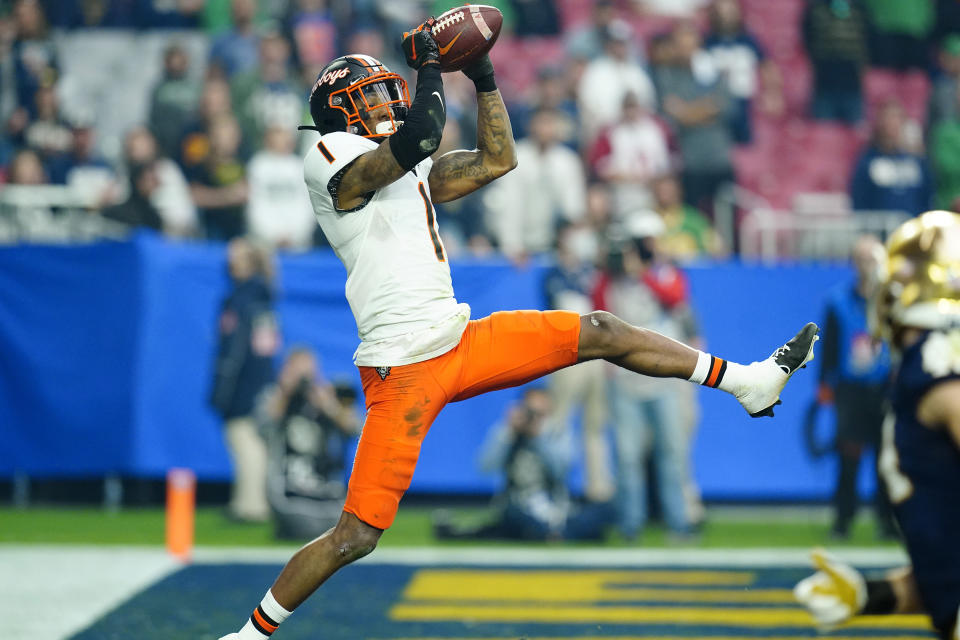 Oklahoma State wide receiver Tay Martin (1) pulls in a touchdown pass during the first half of the Fiesta Bowl NCAA college football game against Notre Dame, Saturday, Jan. 1, 2022, in Glendale, Ariz. (AP Photo/Ross D. Franklin)