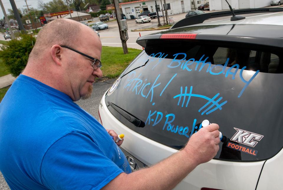 Kennard-Dale powerlifting head coach Niko Hulslander writes Happy Birthday on the back of his SUV before leading the drive-by birthday caravan past Patrick Maloney's home in May of 2020. Maloney suffered a brain injury on the football field that previous fall.