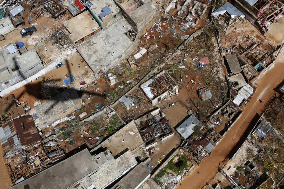 <p>The shadow of a CH-47 Fox Chinook helicopter passes over damaged houses in southwestern Haiti, as the U.S. military flies a delivery of rice for Hurricane Matthew relief efforts to the mountain village of Beaumont, near Jeremie, Haiti, Thursday, Oct. 13, 2016. (AP Photo/Rebecca Blackwell)</p>