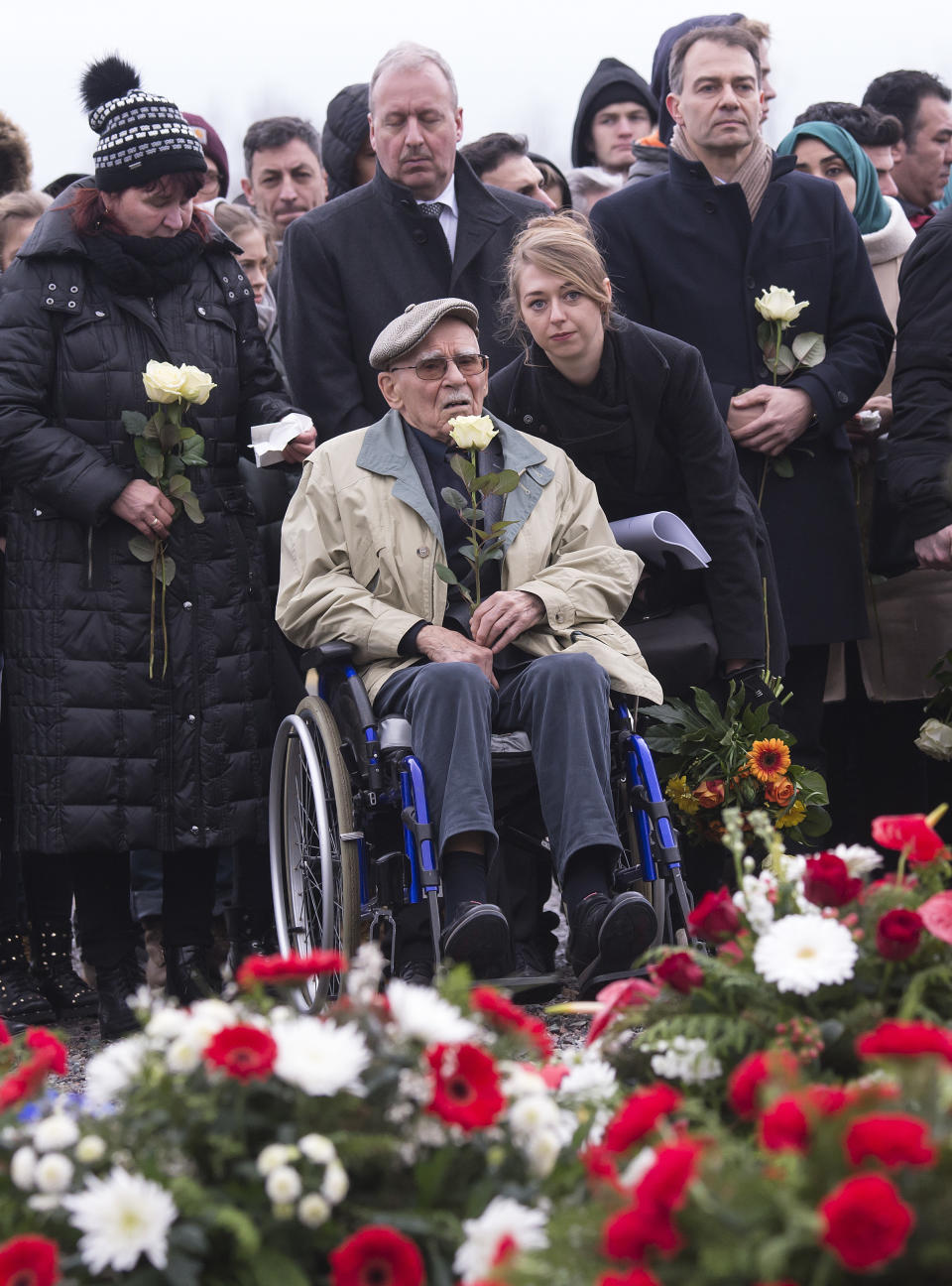 <p>Former Nazi concentration camp survivor Raymond Renaud of France, center, holds a white rose during the wreath-laying ceremony on occasion of the international Holocaust remembrance day (Jan. 27) in the former Nazi concentration camp Buchenwald near Weimar, Germany, Friday, Jan. 26, 2018. (Photo: Jens Meyer/AP) </p>