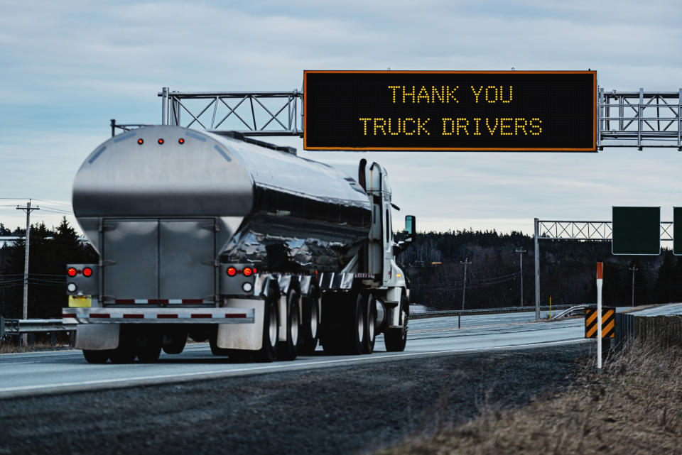 Thank You Truck Drivers on an overhead highway sign during the Coronavirus pandemic, out of focus semi truck in foreground.