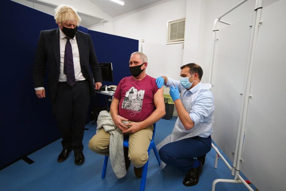 Prime Minister Boris Johnson watches someone receive their Covid-19 booster vaccine (Peter Byrne/PA) (PA Wire)