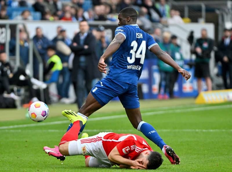 Union Berlin's Kevin Volland (L) is fouled by Hoffenheim's Stanley N'Soki during the German Bundesliga soccer match between TSG 1899 Hoffenheim and 1. FC Union Berlin at the PreZero Arena. Jan-Philipp Strobel/dpa