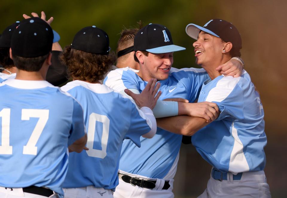 The Alliance baseball team, including Eric Bennett, celebrates with winning pitcher Tra'Sean Williams, far right, after a win at Marlington to clinch the EBC title, Friday, March 5, 2023.