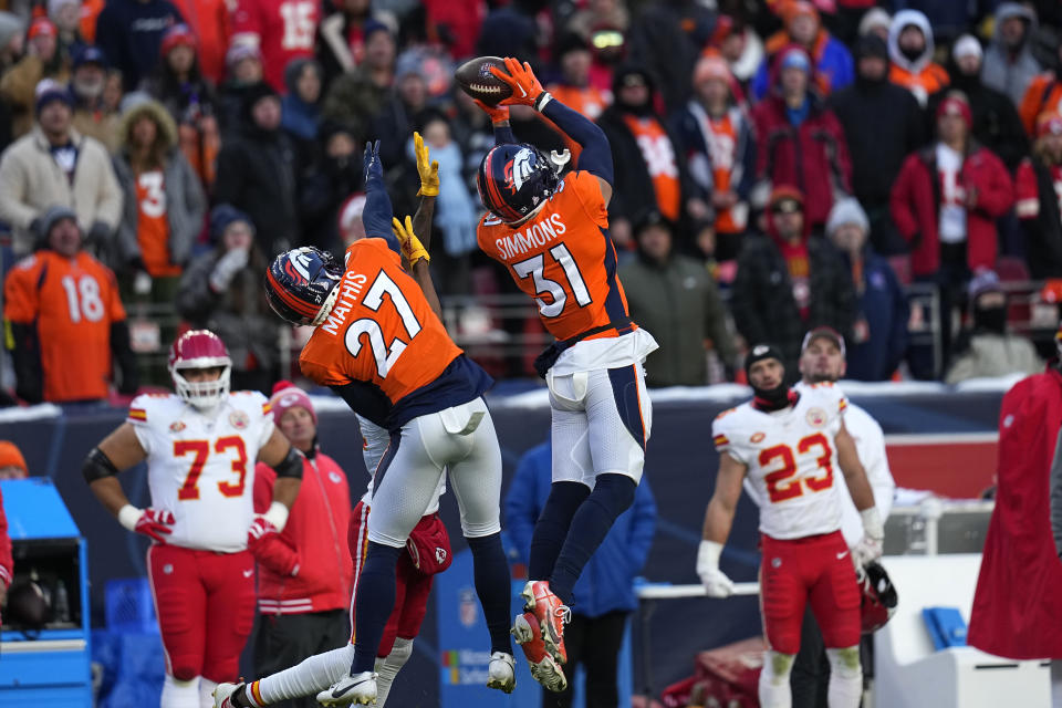 FILE - Denver Broncos safety Justin Simmons (31) intercepts a pass as teammate Damarri Mathis (27) watches during the second half of an NFL football game against the Kansas City Chiefs Sunday, Oct. 29, 2023, in Denver. Simmons was voted one of the top five safeties at the midpoint of the season by The Associated Press. (AP Photo/Jack Dempsey, File)