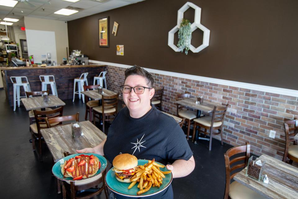 Alex Tricarico, owner of MorningStar Cafe in Toms River, holds a plate of strawberry shortcake pancakes and a Daisy burger with french fries.