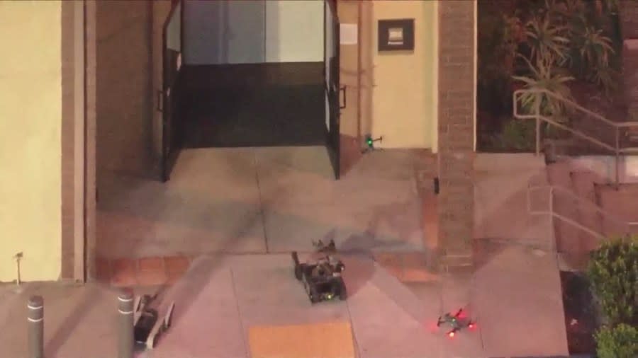 Remote-controlled robots and drones carefully enter and inspect a Wells Fargo bank after a bomb threat on March 26, 2024. (KTLA)