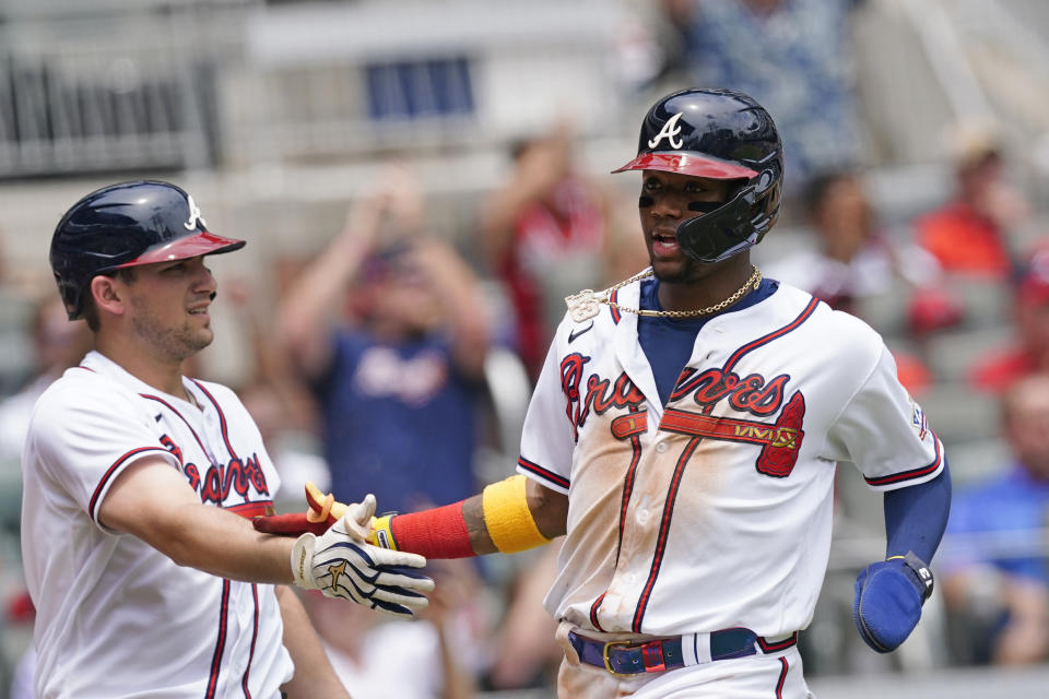Atlanta Braves' Ronald Acuna Jr., right, is greeted at home plate by Austin Riley after scoring on an Ozzie Albies' base hit in the sixth inning of a baseball game against the Washington Nationals, Thursday, June 3, 2021, in Atlanta. (AP Photo/John Bazemore)