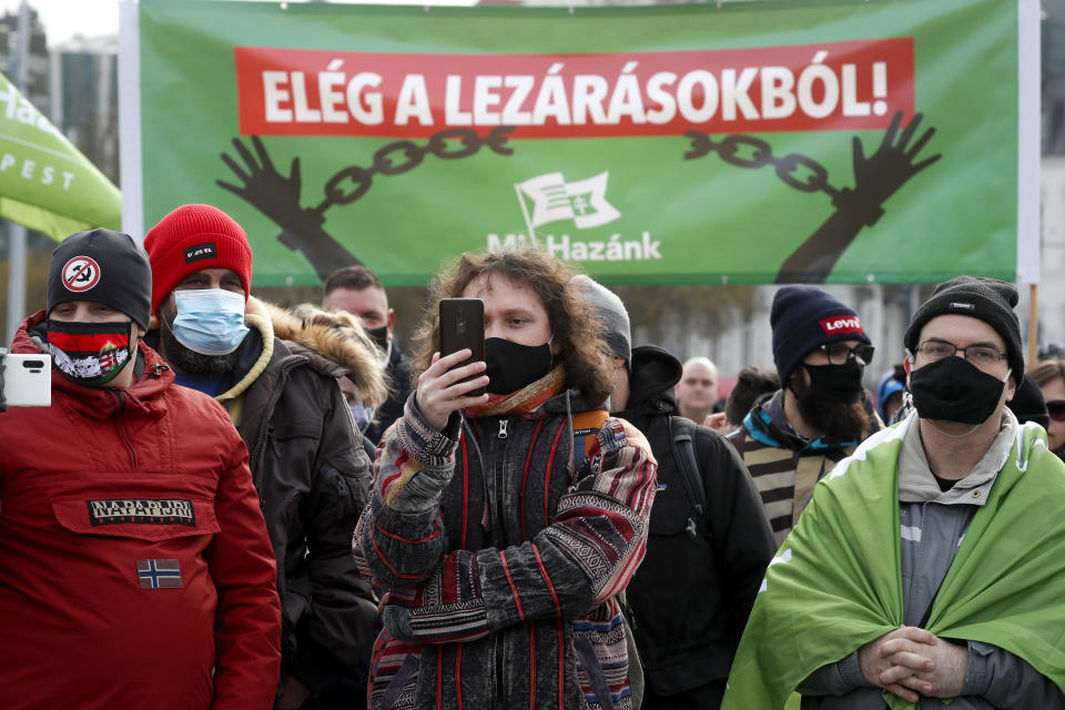 Hospitality sector workers, backdropped by a banner reading 'Stop the Restrictions" attend a protest, in Budapest, Hungary, Sunday, Jan. 31, 2021. Protesters gathered at a central square in Hungary's capital of Budapest on Sunday demanding a rethinking of the country's lockdown restrictions. As the lockdown limiting restaurants to take-away service approaches the three-month mark, many business owners complain that they have received little to none of the government’s promised financial assistance while other businesses like shopping malls and retail stores have been permitted to remain open. (AP Photo/Laszlo Balogh)