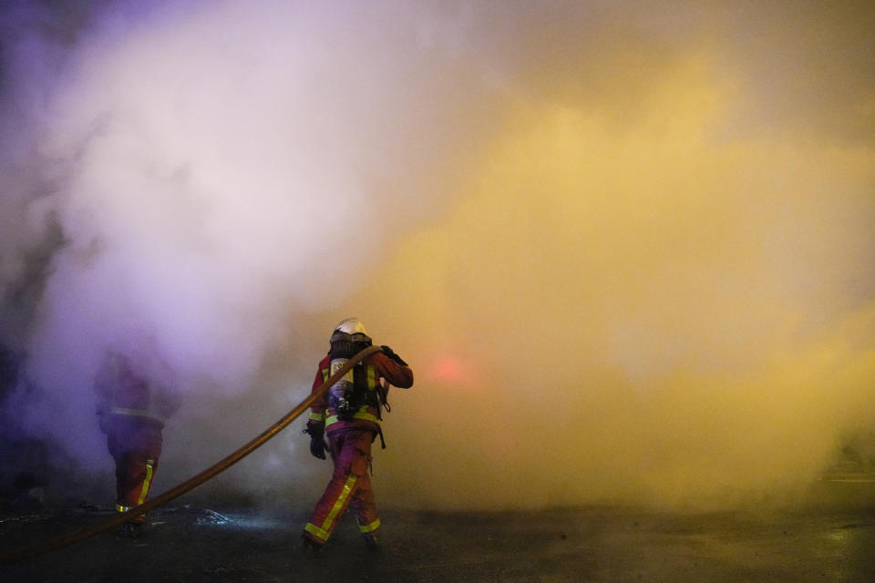 Firefighters extinguish the flame in Nanterre, outside Paris, France, Saturday, July 1, 2023. French President Emmanuel Macron urged parents Friday to keep teenagers at home and proposed restrictions on social media to quell rioting spreading across France over the fatal police shooting of a 17-year-old driver. (AP Photo/Lewis Joly)