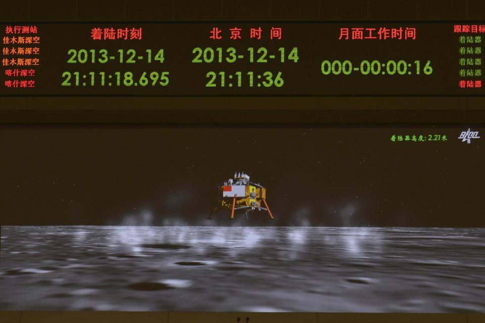 A photograph taken on a giant screen at the Beijing Aerospace Control Center in Beijing shows an animated image of the Chang'e-3 lunar probe landing onto the surface of the moon