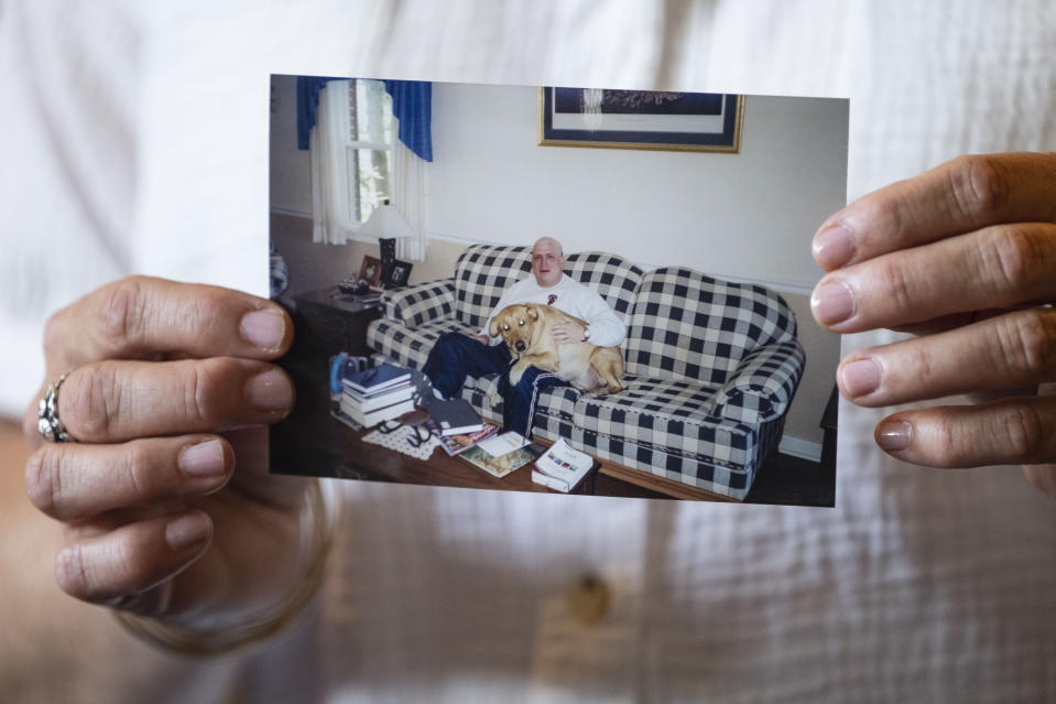 Doreen Jenness, the widow of Air Force Capt. Jason Jenness, holds up a photo of Jason during an interview with the Associated Press in Missoula, Mont., Aug. 26, 2023. Capt. Jenness was a Malmstrom missileer who died of non-Hodgkin lymphoma in 2001 at the age of 31. (AP Photo/Tommy Martino)