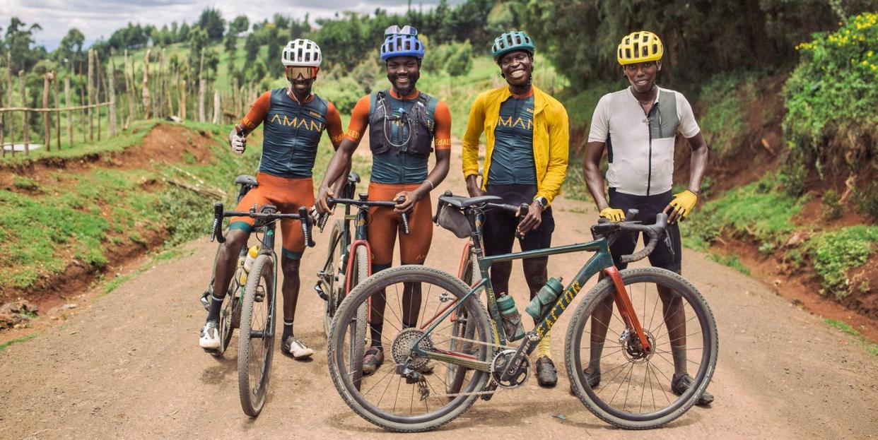 four cyclists on team amani pose for a portrait with their bikes while on a training ride on a gravel road outside iten kenya