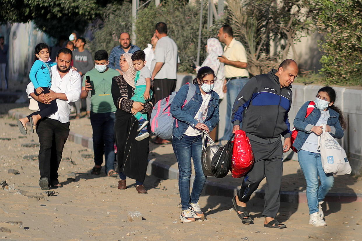 Palestinians evacuate after their tower building was hit by Israeli air strikes, amid a flare-up of Israeli-Palestinian violence, in Gaza City May 12, 2021. REUTERS/Mohammed Salem