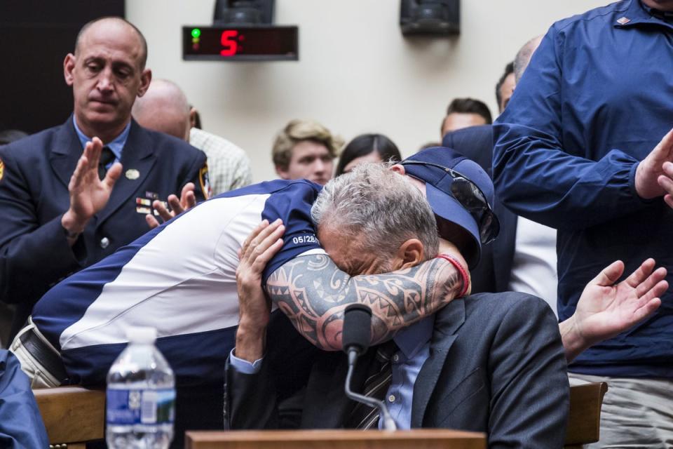 John Feal hugs John Stewart in 2011 as they successfully lobby Congress to provide compensation to 9/11 first responders (Getty)
