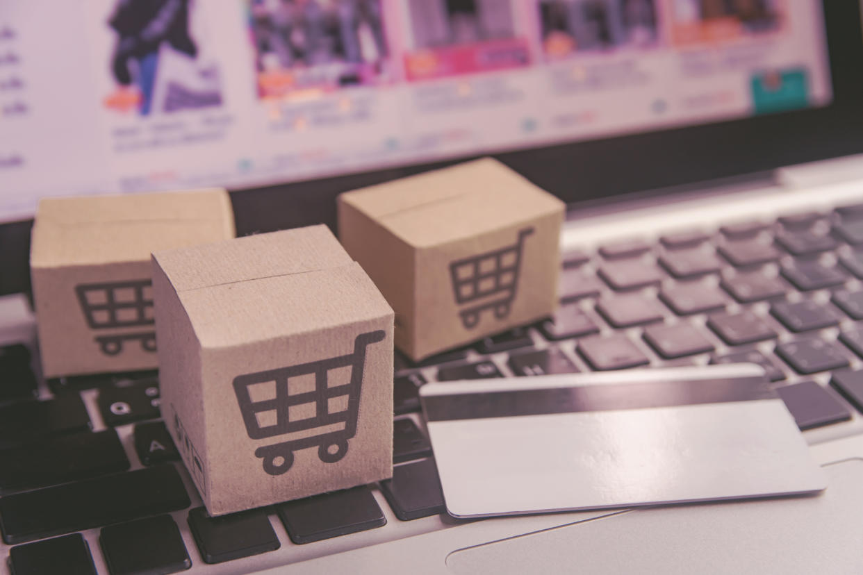 Online shopping - Paper cartons or parcel with a shopping cart logo and credit card on a laptop keyboard. Shopping service on The online web and offers home delivery.