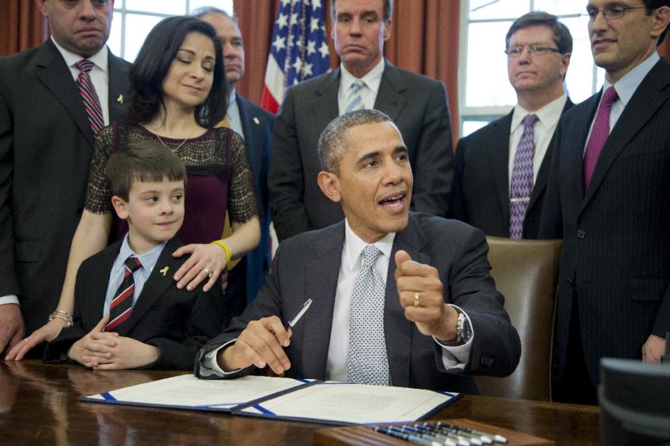 President Barack Obama with Jake Miller, left, and Ellyn Miller, behind Jake, brother and mother of Gabriela Miller, talks about the Gabriella Miller Kids First Research Act, before signing it into law, Thursday, April 3, 2014, in the Oval Office of the White House in Washington. (AP Photo/Manuel Balce Ceneta)