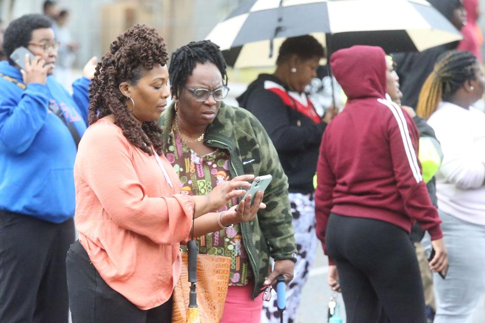 Family members look at social media posts on their phone as they wait to pick up their students on Wednesday November 30, 2022 at Savannah High. 