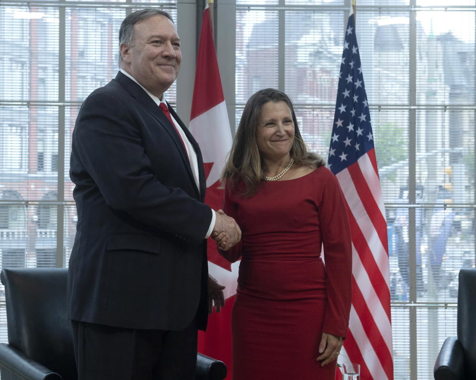 Canadian Foreign Affairs Minister Chrystia Freeland shakes hands with U.S. Secretary of State Mike Pompeo as he lays a wreath at the National War Memorial in Ottawa, Thursday, Aug. 22, 2019. (Adrian Wyld/The Canadian Press via AP)