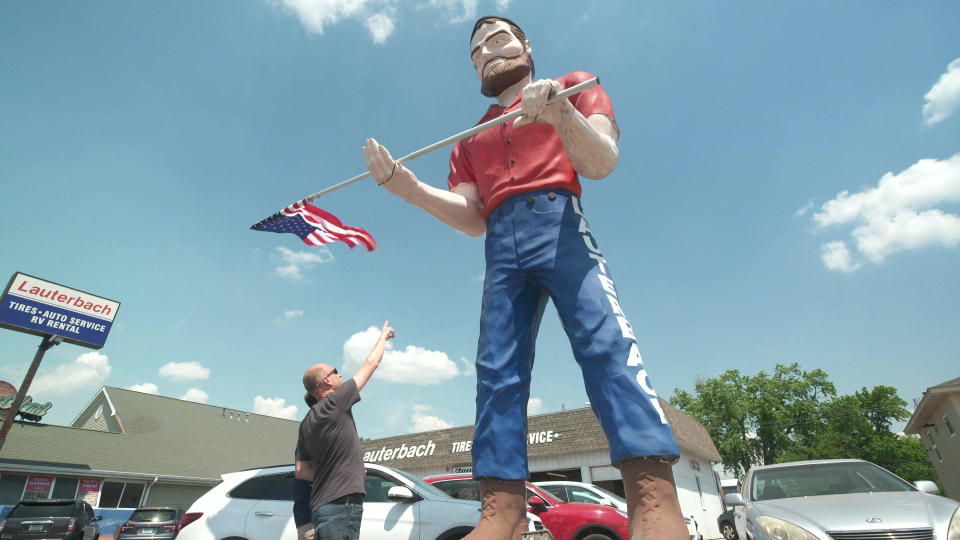 Joel Baker points out an early version of the Muffler Man now standing outside Lauterbach Tire & Auto Service in Springfield, Illinois. / Credit: CBS News
