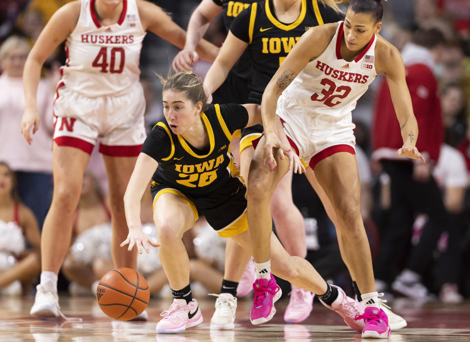 Iowa's Kate Martin (20) knocks the ball away from Nebraska's Kendall Coley (32) during the second half of an NCAA college basketball game Sunday, Feb. 11, 2024, in Lincoln, Neb. (AP Photo/Rebecca S. Gratz)