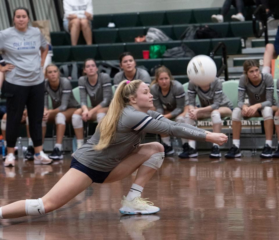 Gulf Breeze High School's Bella Satterwhite (No. 15) digs a Catholic High School serve during Thursday night's match against the Crusaders. The Dolphins defeated the Crusaders in three straight games, 25-16, 25-16, 25-17.