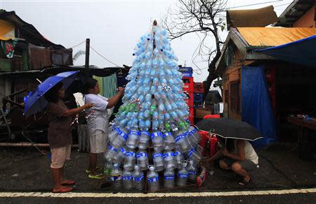 Victims of super Typhoon Haiyan decorate their improvised Christmas tree with empty cans and bottles at the ravaged town of Anibong