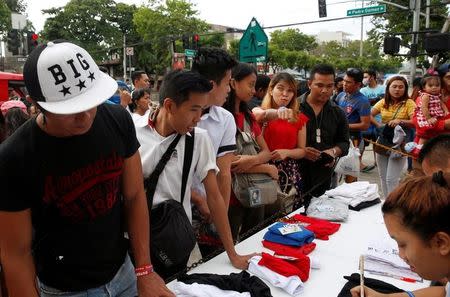 Supporters of presidential candidate Rodrigo "Digong" Duterte queue for campaign shirts a day before the election, in Davao city in southern Philippines May 8, 2016. REUTERS/Erik De Castro