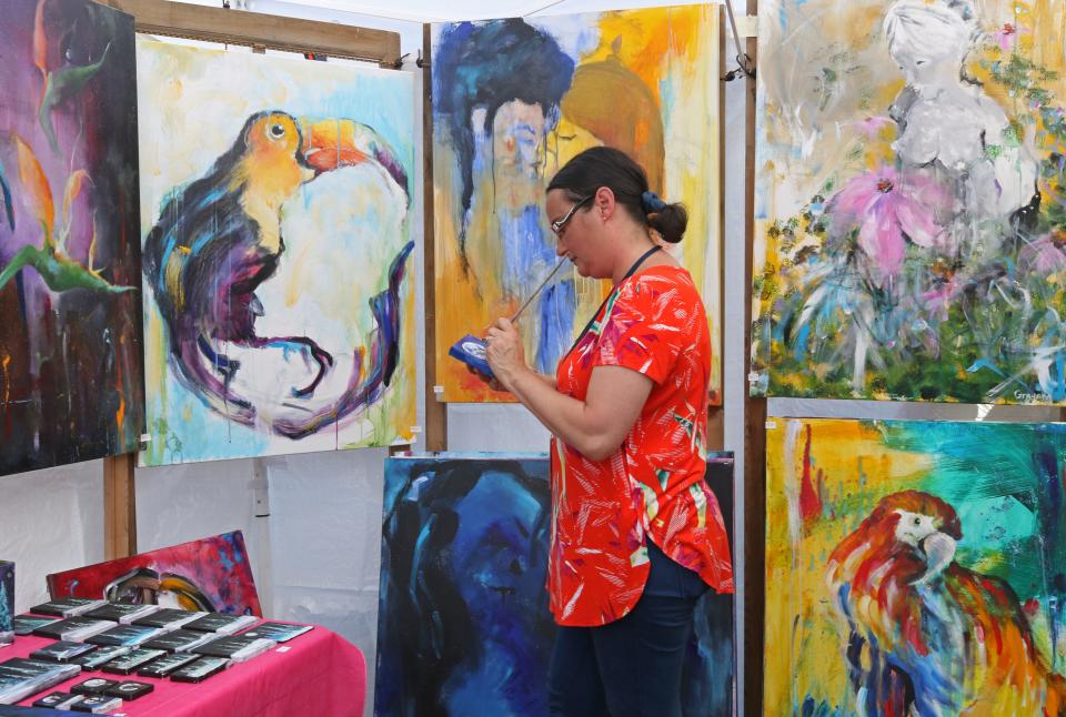 Stacey Graham, of Chepachet, works on a painting in her booth at the 2018 Scituate Art Festival.