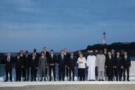 The G7 leaders wrapped up their long day with a group photo on a stage overlooking the Biarritz beach, with the city's tall lighthouse in the background