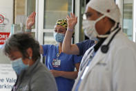 Health care workers wave to a departing patient, who recovered from being stricken with COVID-19, outside the Southern New Hampshire Medical Center in Nashua, N.H., Wednesday, May 27, 2020. (AP Photo/Charles Krupa)