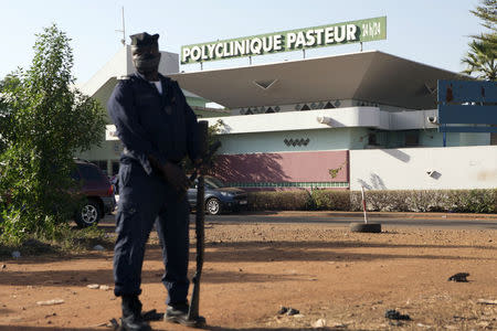 A police officer stands guard outside the quarantined Pasteur Clinic in Bamako November 12, 2014. REUTERS/Joe Penney