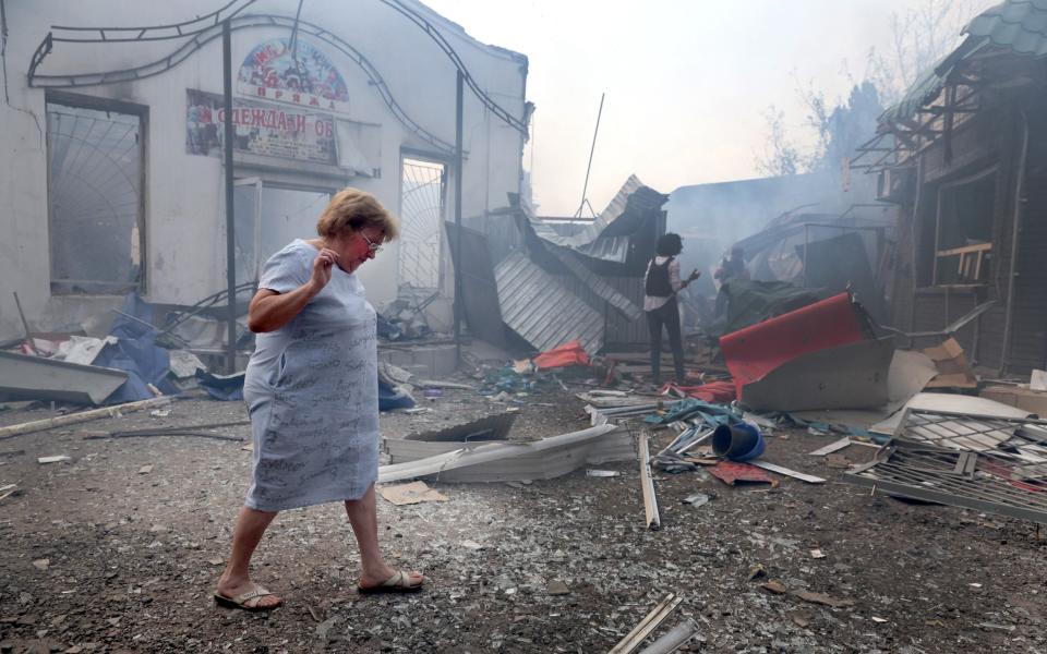 A woman walks through the rubble after a missile struck a shopping mall in Sloviansk - Scott Olson 