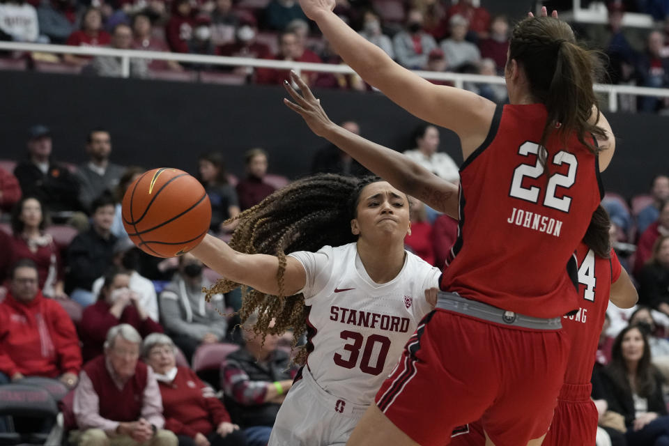 Stanford guard Haley Jones (30) passes the ball while defended by Utah forwards Jenna Johnson (22) and Dasia Young during the first half of an NCAA college basketball game in Stanford, Calif., Friday, Jan. 20, 2023. (AP Photo/Godofredo A. Vásquez)