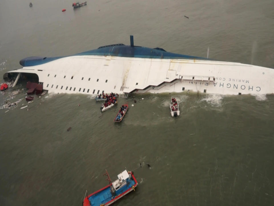 In this photo released by South Korea Coast Guard via Yonhap News Agency, South Korean rescue team boats and fishing boats try to rescue passengers of a ferry sinking off South Korea's southern coast, in the water off the southern coast near Jindo, south of Seoul, Wednesday, April 16, 2014. Nearly 300 people were still missing Wednesday several hours after a ferry carrying 459, most of them high school students, sank in cold waters off South Korea's southern coast. (AP Photo/South Korea Coast Guard via Yonhap) KOREA OUT