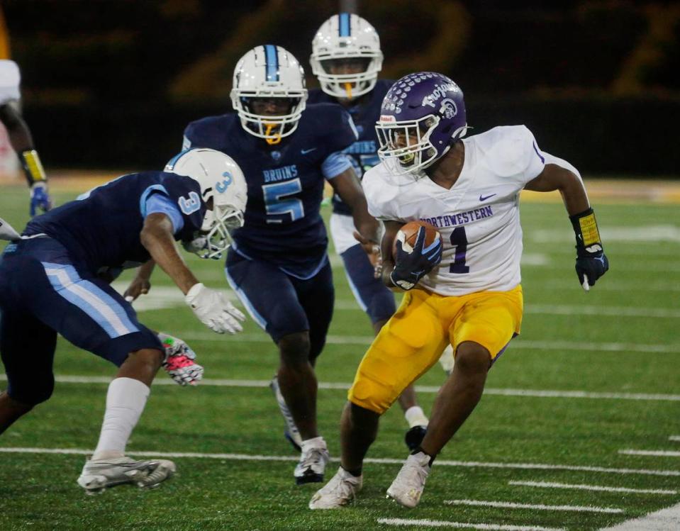 Northwestern’s Turbo Richard (1), tires to avoid South Florence’s Quincy Rhodes Jr. Saturday as the Trojans and Bruins compete for the Class 4A state championship title in Columbia. Tracy Kimball/tkimball@heraldonline.com