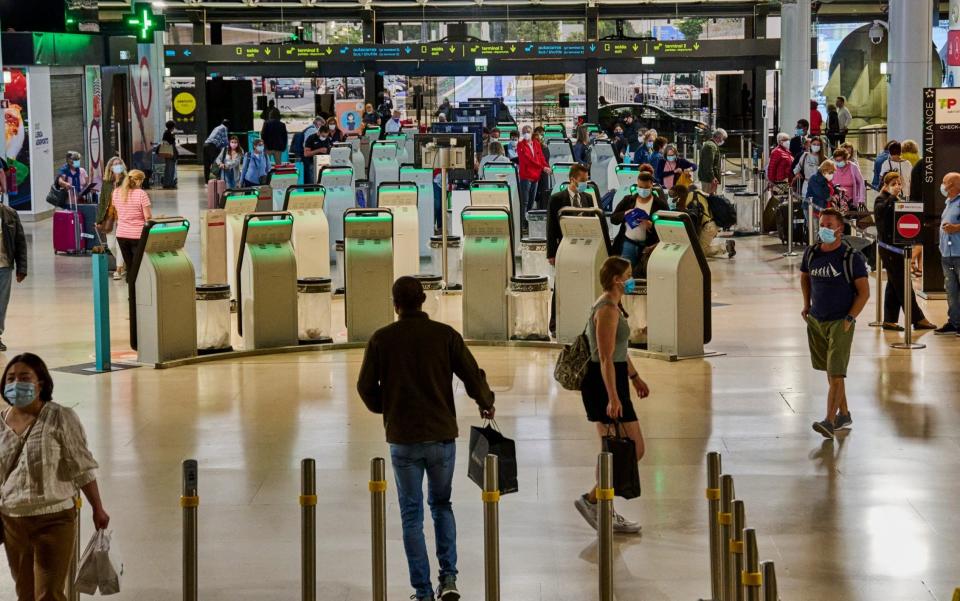 In Lisbon, Portugal, mask-clad departing travellers use the self check-in machines and queue - Horacio Villalobos/Corbis via Getty Images